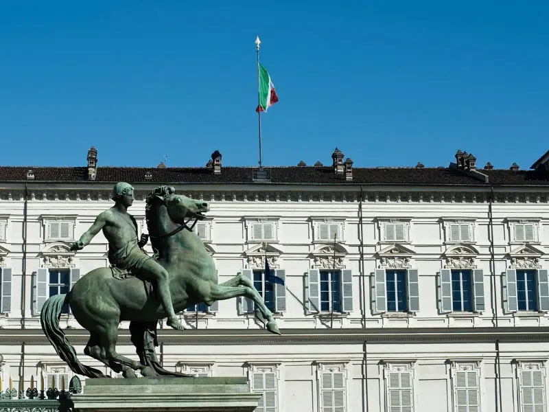 The majestic facade of the Royal Palace of Turin, a grand historical building under a clear sky.